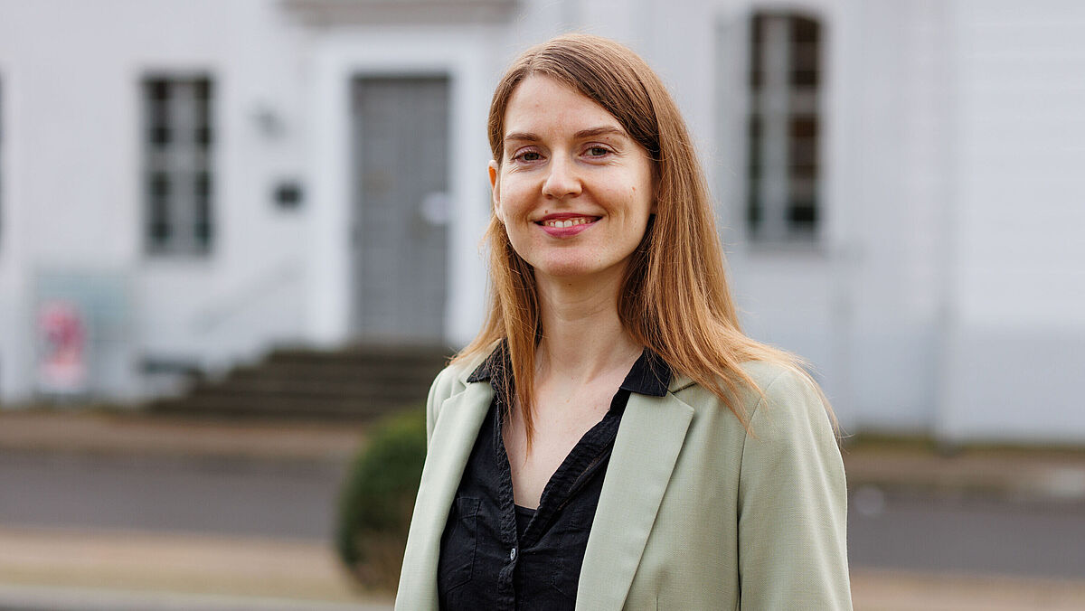 Porträt Fiona Schmidt Auf dem Foto ist Fiona Schmidt vor dem Unihauptgebäude zu sehen.
