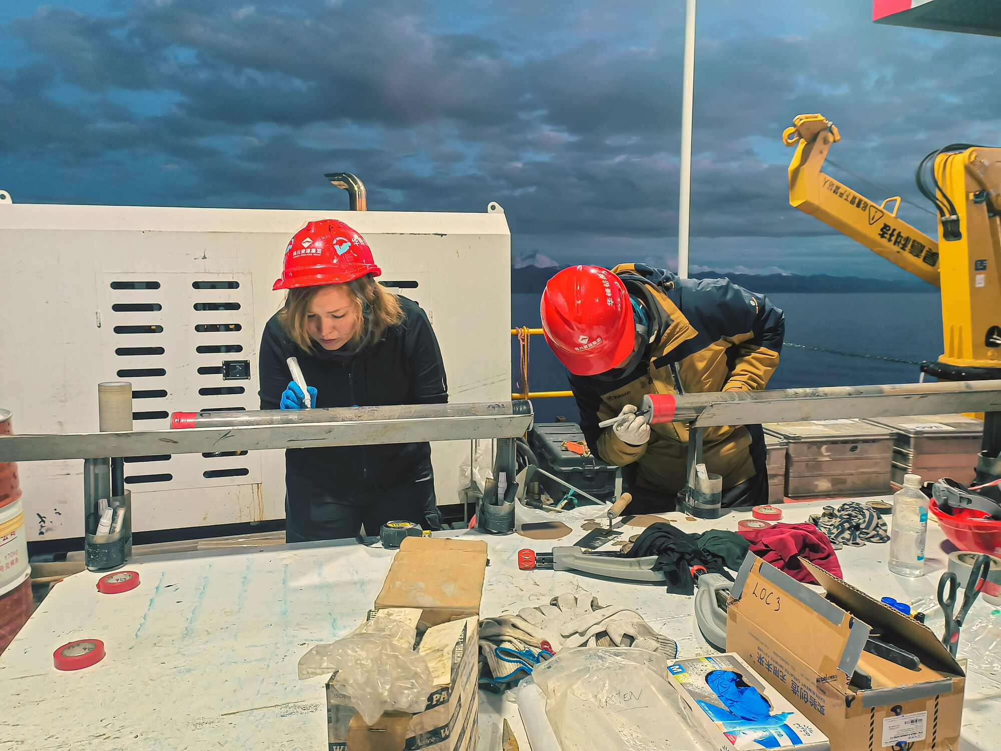 Before the sediment cores from Lake Namco can be analysed in the laboratories, they are cleaned and labelled on board of the drilling platform. © Olga Gildeeva Before the sediment cores from Lake Namco can be analysed in the laboratories, they are cleaned and labelled on board of the drilling platform. © Olga Gildeeva