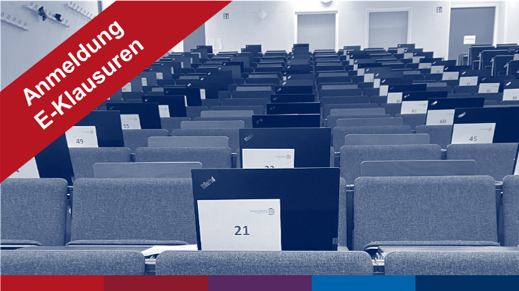 Laptops im Hörsaal mit Banner "Anmeldung E-Klausuren"