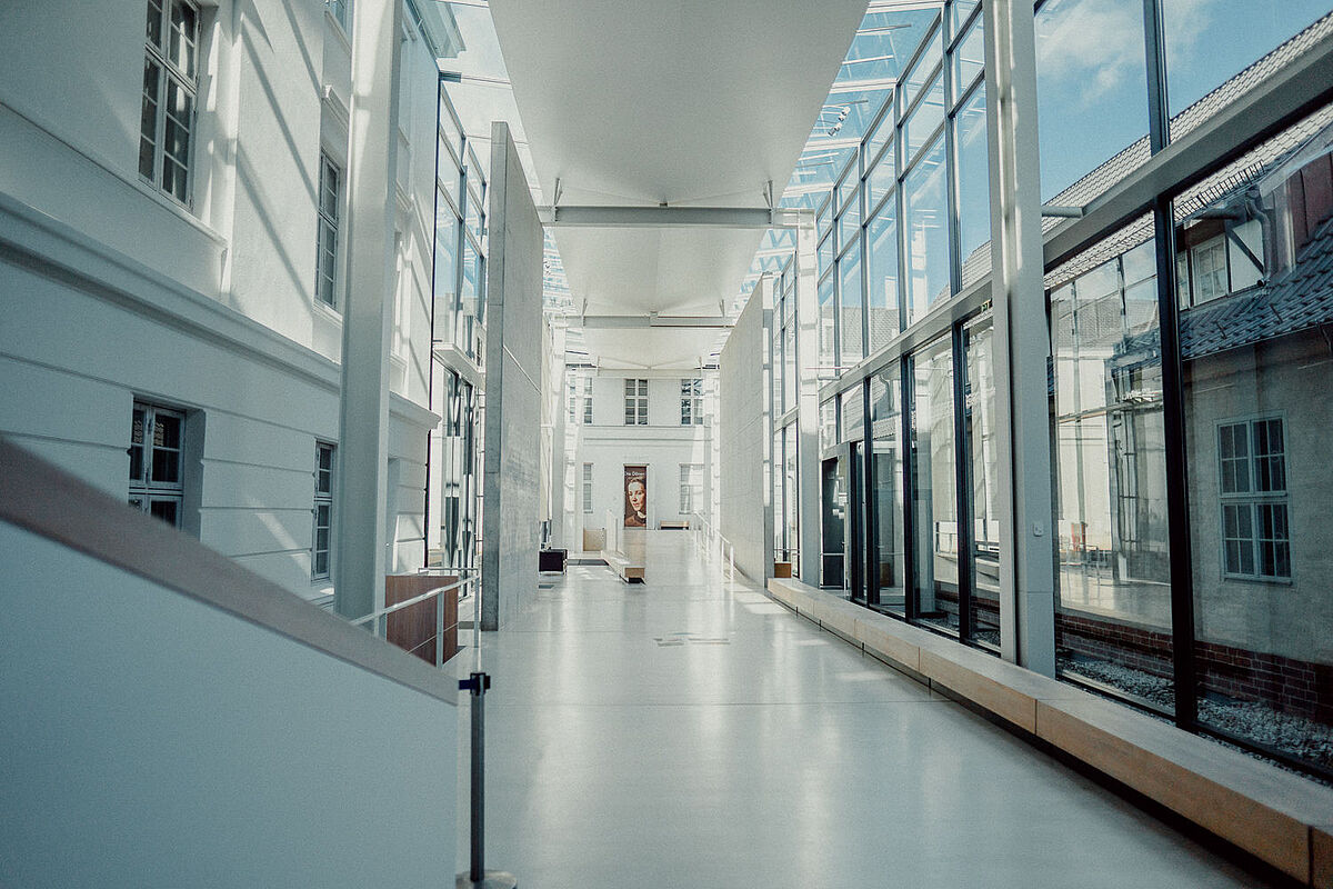 Pommersches Landesmuseum Blick in den hellen Flur des Pommerschen Landesmuseums. Rechts ist eine große Glasfassade, in die viel Licht einfällt.