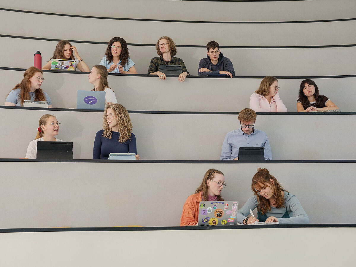 Imagefilm Grundschullehramt Studierende sitzen in einem Hörsaal und unterhalten sich.