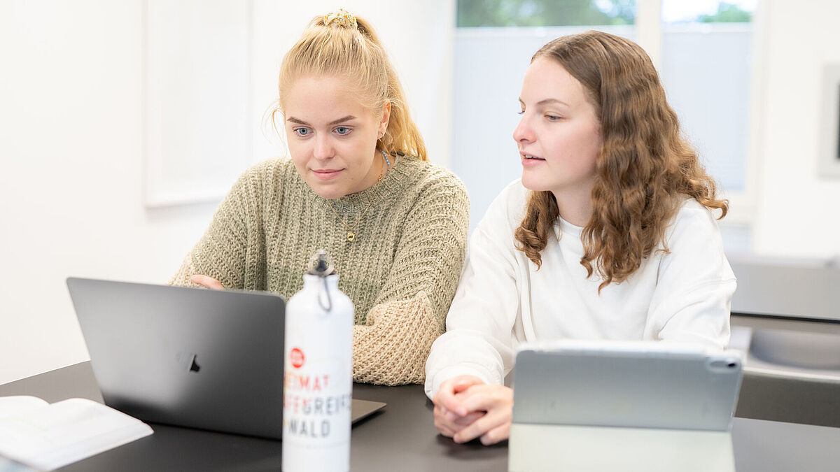 Studierende arbeiten im Unirechenzentrum Zwei Studentinnen sitzen nebeneinander an ihren Notebooks und tauschen sich aus.