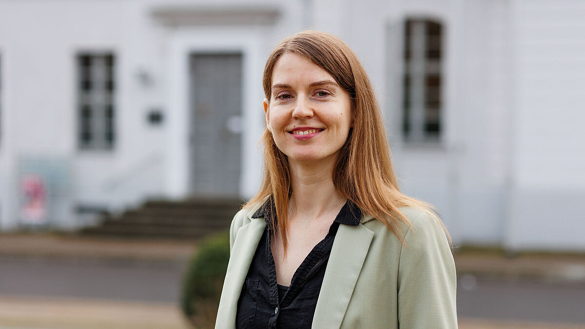 Portrait Fiona Schmidt The photo shows Fiona Schmidt in front of the main university building.