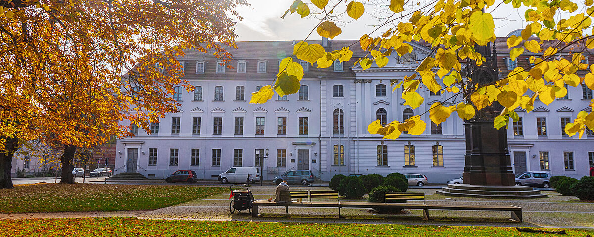 The photo shows the University Main Building in autumn