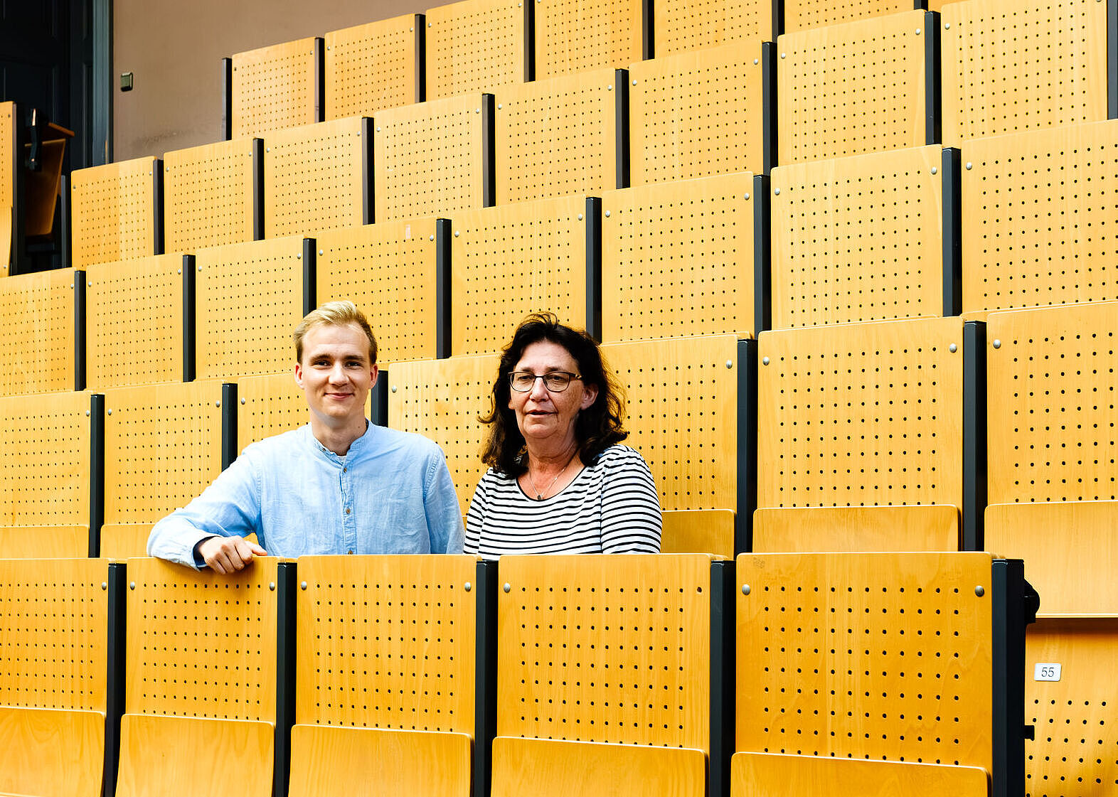 Schulleiterin Anke Thurow und Lukas Voigt, Studentische Prorektor der Universität Greifswald, sitzen nebeneinander im Unihörsaal. 