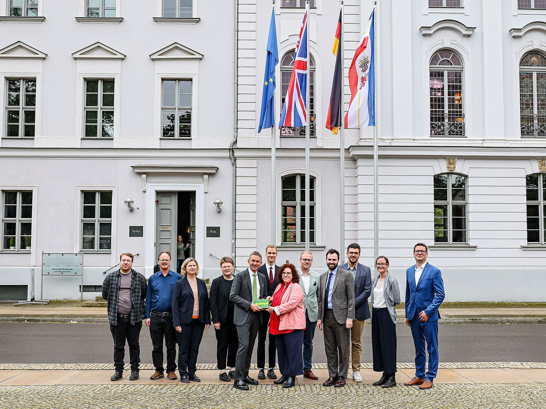 Britischer Botschafter Andrew Mitchell CMG zu Gast Ein Gruppenfoto vor dem Unihauptgebäude mit dem britischer Botschafter Andrew Mitchell CMG.