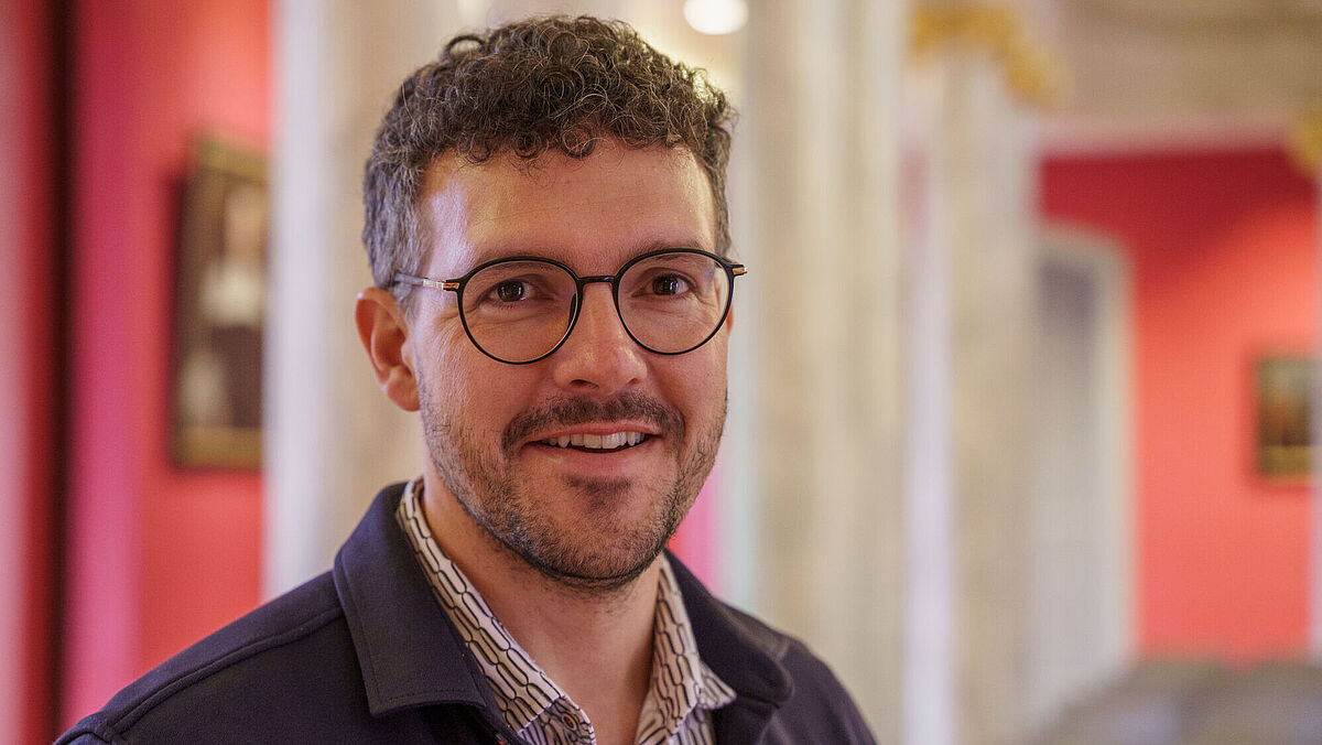 Christopher Gray Das Bild zeigt eine Porträtaufnahme von Christopher Gray in der Aula der Universität Greifswald