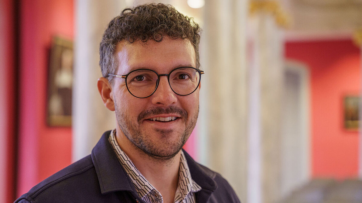 Portrait Christopher Gray The photo is a portrait of Christopher Gray in the University of Greifswald's Aula