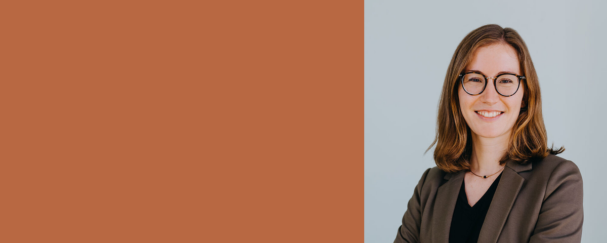 Frau mit langen braunen Haaren und schwarzer Brille