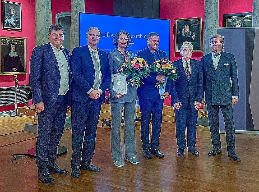 Preisverleihung an Katharina Hoff und Prof. Dr. Klaus-Dieter Weltmann, sie posieren mit Blumenstrauß und Urkunde