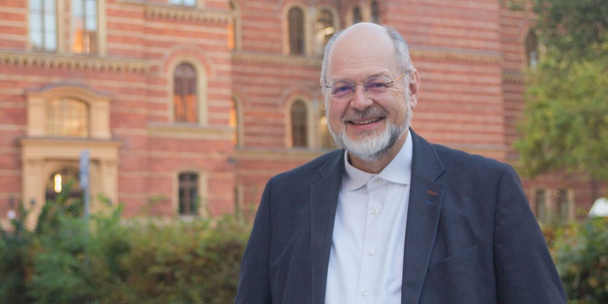 Prof. Dr. Olaf Hohmann Prof. Dr. Olaf Hohmann steht vor einem Gebäude.