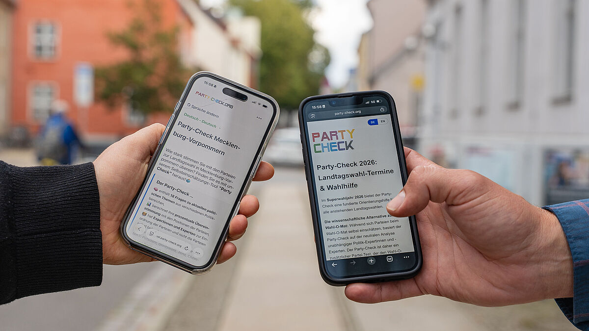 Onlinewahlhilfe 2026 Die Onlinewahlhilfe-App auf dem Smartphone. Zu sehen sind jeweils eine Hand zweier Personen, die Smartphones halten.