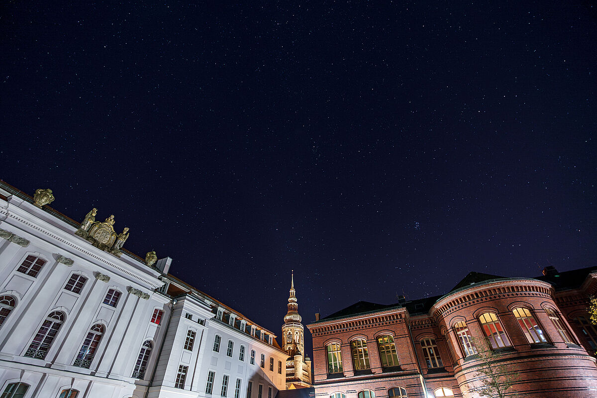 Historischer Campus mit Sternenhimmel Auf dem Bild ist der Historischer Campus mit Sternenhimmel zu sehen. Links erkennt man das Hauptgebäude und rechts das Alte Audimax. Dazwischen ist der beleuchtete Mond zu sehen.