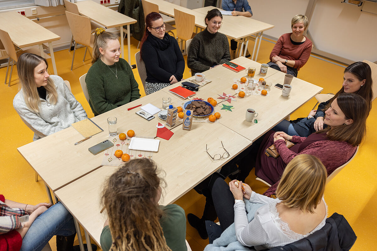 Netzwerktreffe. Frauen sitzen um einen Tisch und reden.