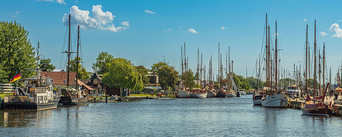 Museumshafen Greifswald Der Fluß Ryck schlängelt sich bei Sonnenschein durch die Stadt, vorbei an zahlreichen Schiffen