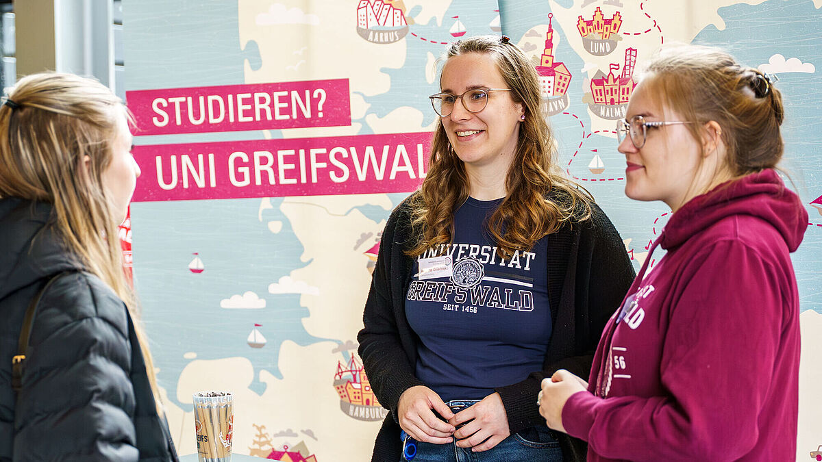 Symbolbild Hochschulinfotage Zwei Studienberaterinnen beraten eine andere Person.