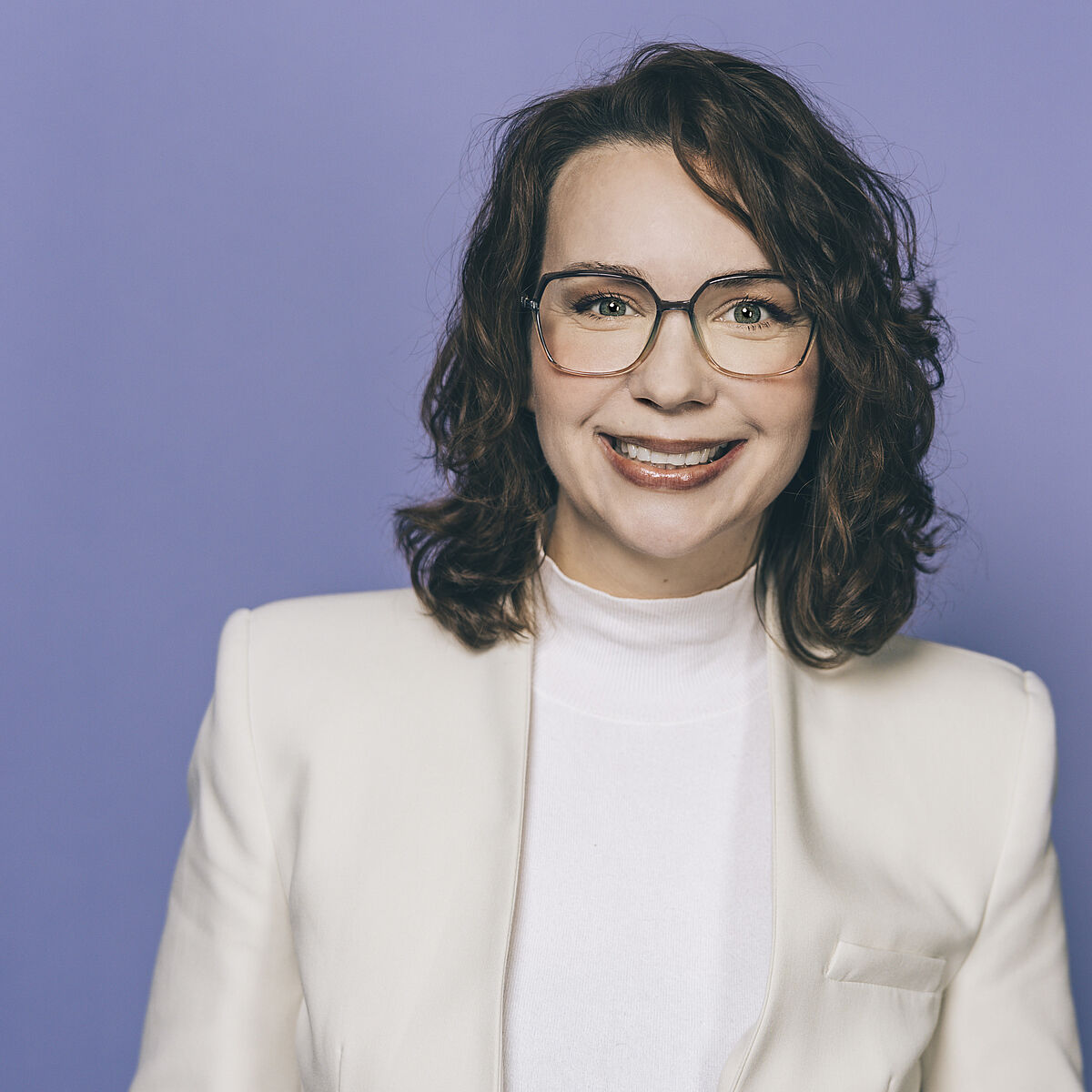 Portraitfoto von Susanne Kabatnik vor blauem Hintergrund