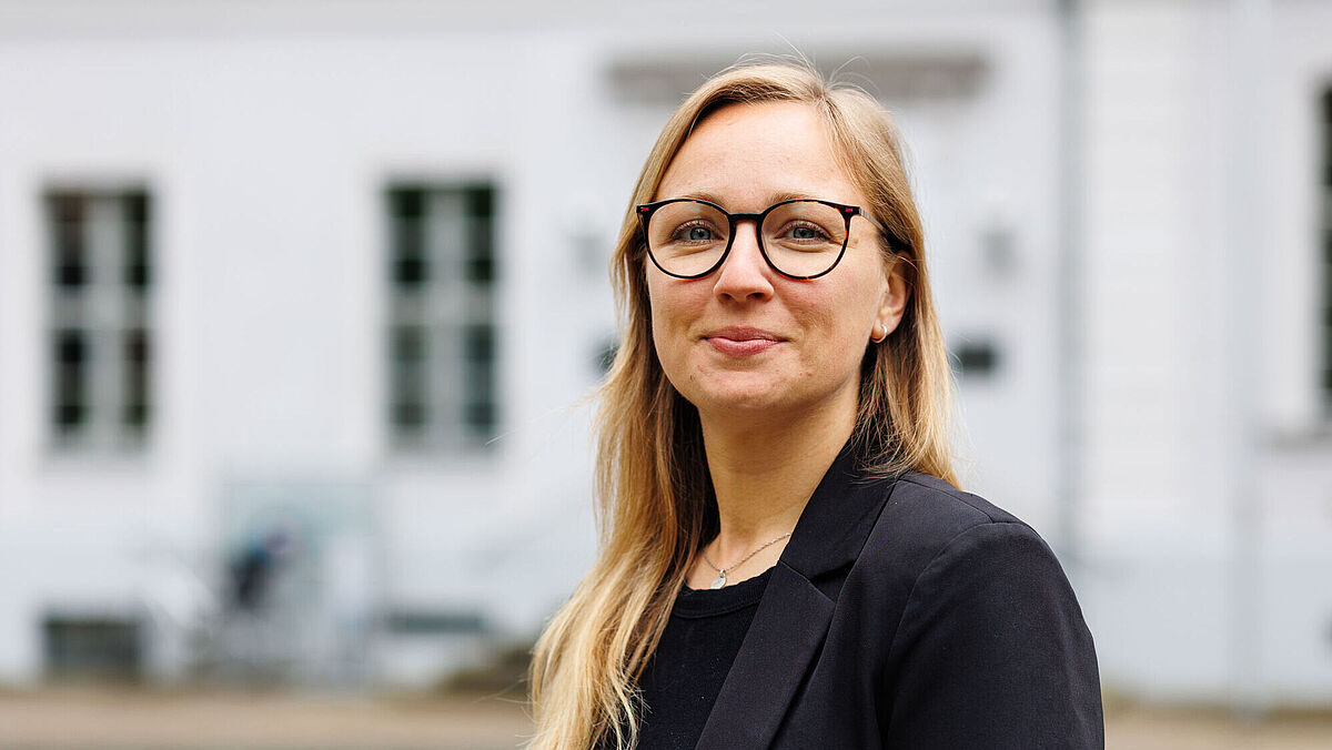 Portrait Lisa Kuhlmann Lisa Kuhlmann in front of the main building of the University of Greifswald