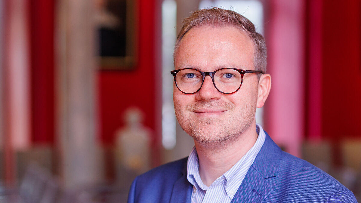 Rick Tazelaar Auf dem Bild ist ein Porträt von Rick Tazelaar zu sehen. Es wurde in der Aula der Universität aufgenommen.