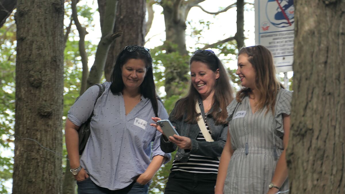 Drei Frauen stehen beieinander und tasuchen Nummern aus.