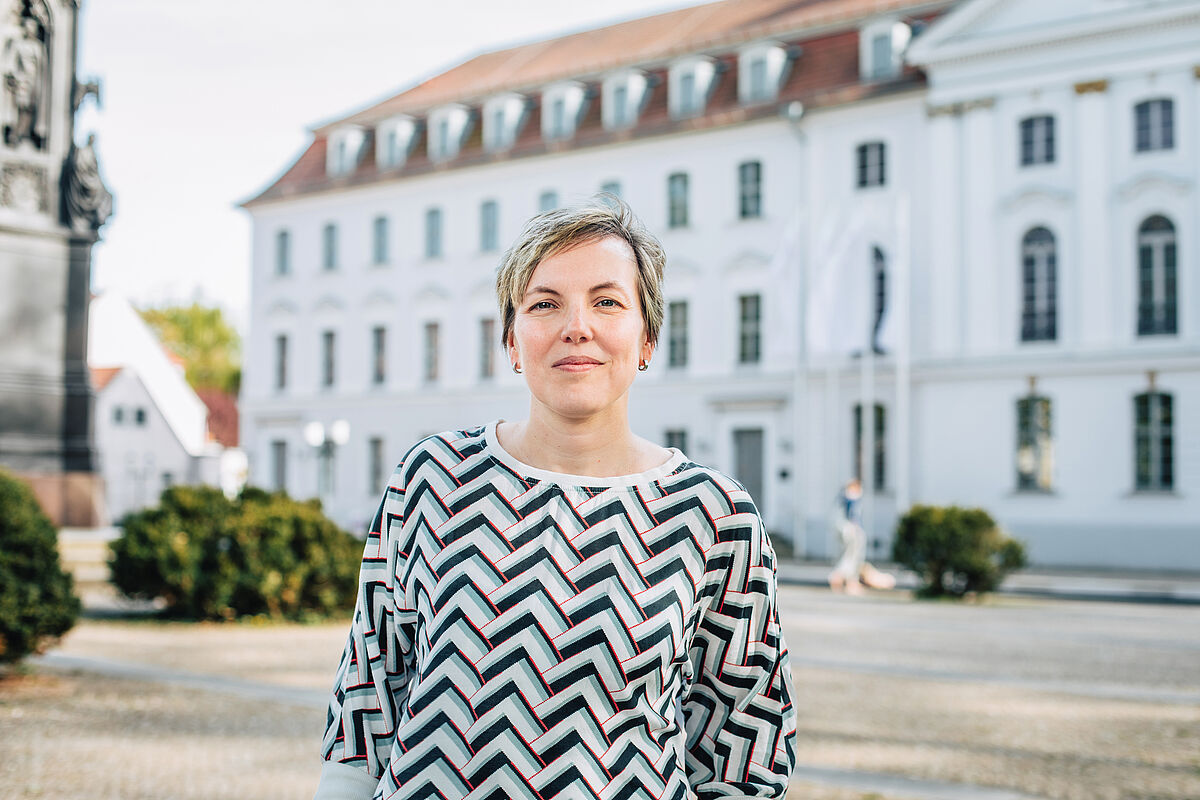 Jenny Linek vor dem historischen Universitätsgebäude