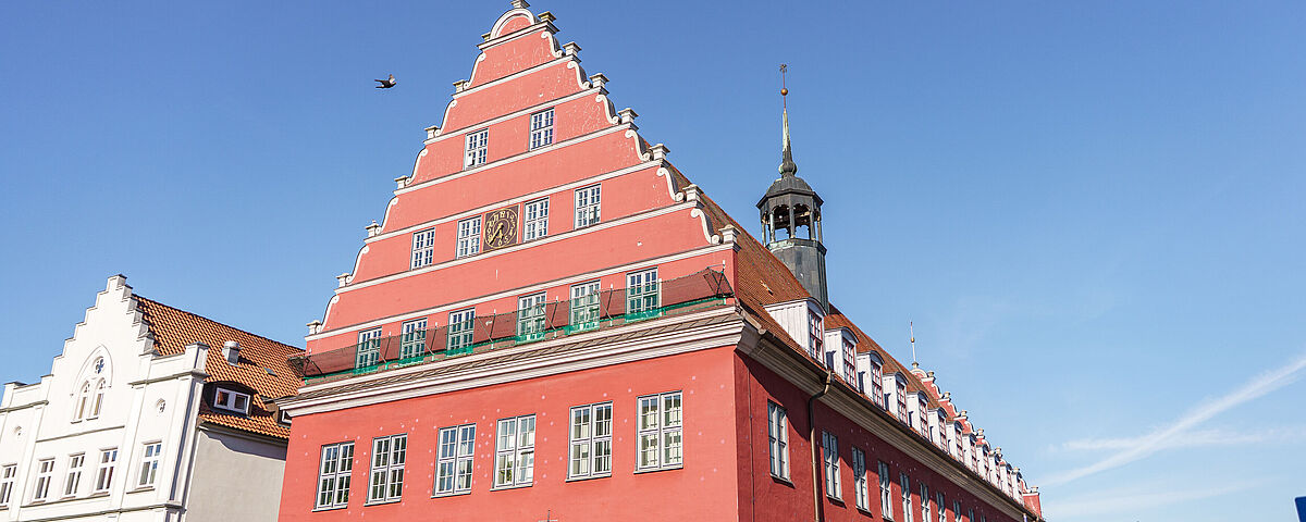 Rathaus Greifswald Das rote Rathaus der Universität Greifswald vor einem strahlend blauen Himmel.